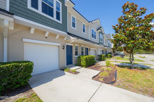 246 Moultrie Village Ln, Saint Augustine, FL 32086 - view of front facade with a garage, concrete driveway, stucco siding, and a residential view