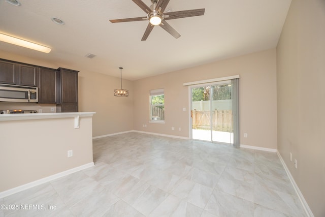 246 Moultrie Village Ln, Saint Augustine, FL 32086 - kitchen featuring stainless steel microwave, dark brown cabinets, ceiling fan, light countertops, and pendant lighting