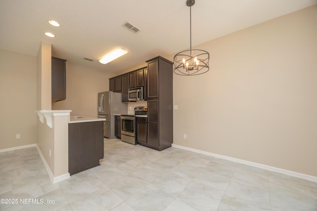 246 Moultrie Village Ln, Saint Augustine, FL 32086 - kitchen with appliances with stainless steel finishes, dark brown cabinetry, a chandelier, a peninsula, and light countertops