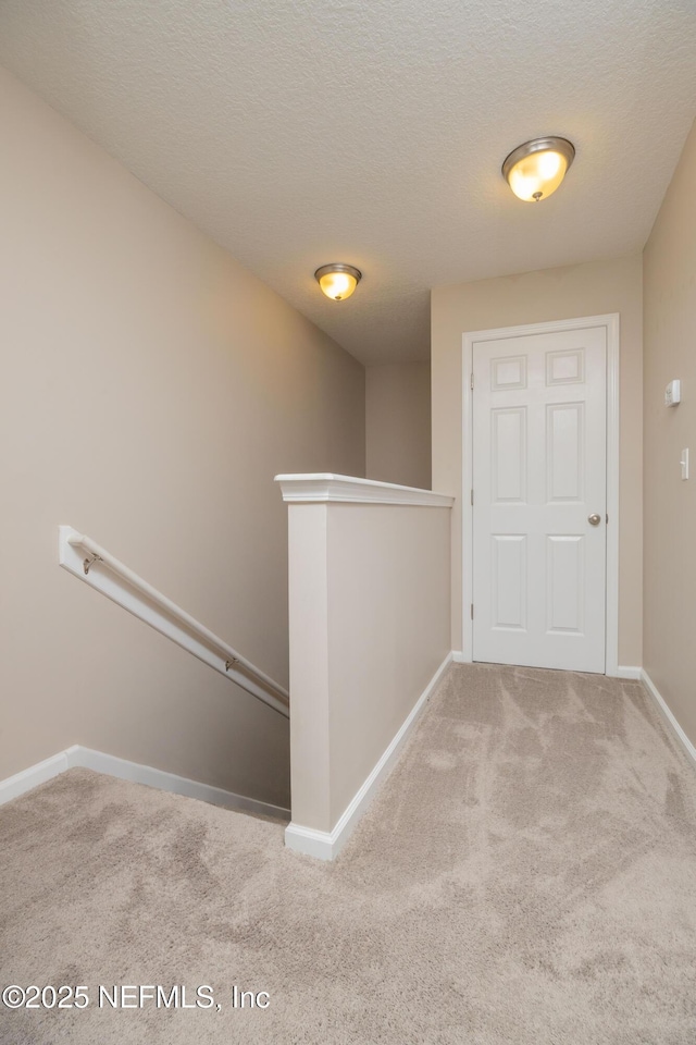 246 Moultrie Village Ln, Saint Augustine, FL 32086 - corridor featuring an upstairs landing, carpet floors, baseboards, and a textured ceiling