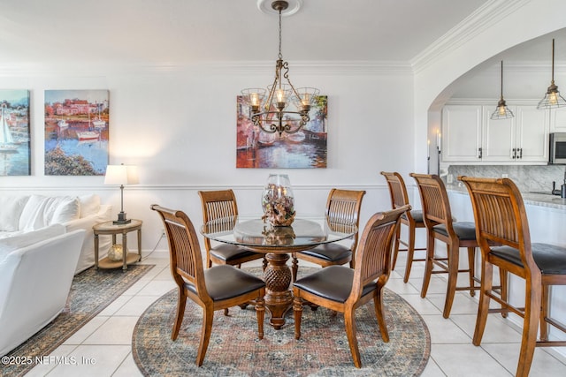 2315 Vista Cove Rd, Saint Augustine, FL 32084 - dining area with light tile patterned floors, crown molding, arched walkways, and a chandelier