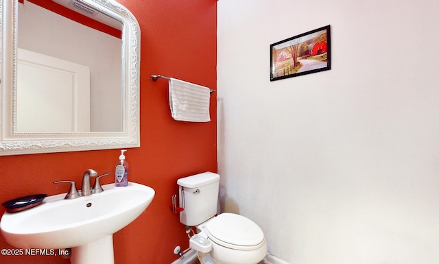 12237 Woodview Dr, Jacksonville, FL 32246 - bathroom featuring baseboards, a sink, and toilet