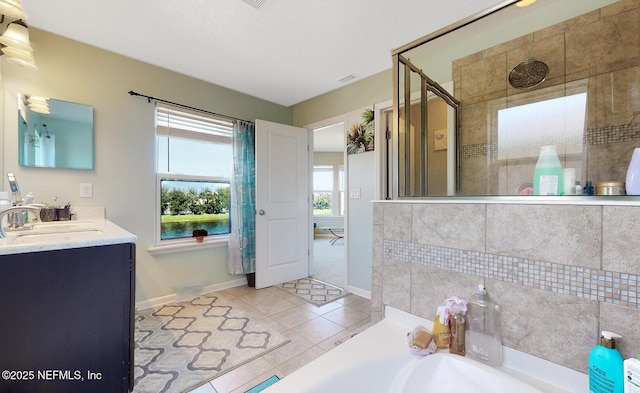 12237 Woodview Dr, Jacksonville, FL 32246 - full bath with baseboards, a bath, a shower stall, tile patterned flooring, and vanity