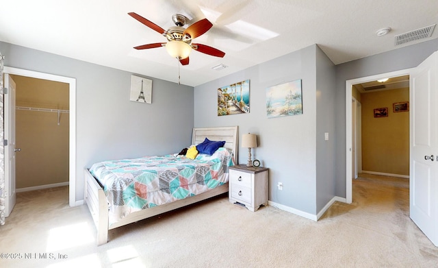 12237 Woodview Dr, Jacksonville, FL 32246 - bedroom with light colored carpet, baseboards, a walk in closet, and ceiling fan