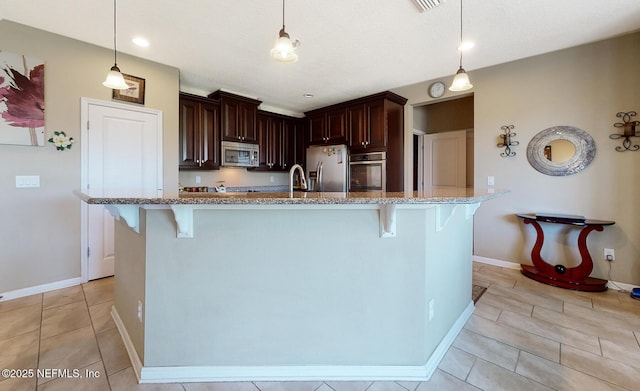 12237 Woodview Dr, Jacksonville, FL 32246 - kitchen featuring appliances with stainless steel finishes, a breakfast bar, light stone countertops, pendant lighting, and recessed lighting
