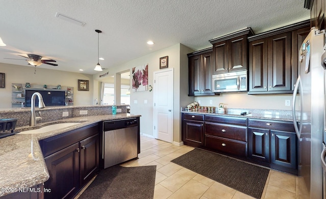12237 Woodview Dr, Jacksonville, FL 32246 - kitchen with stainless steel appliances, a sink, dark brown cabinets, light tile patterned floors, and ceiling fan