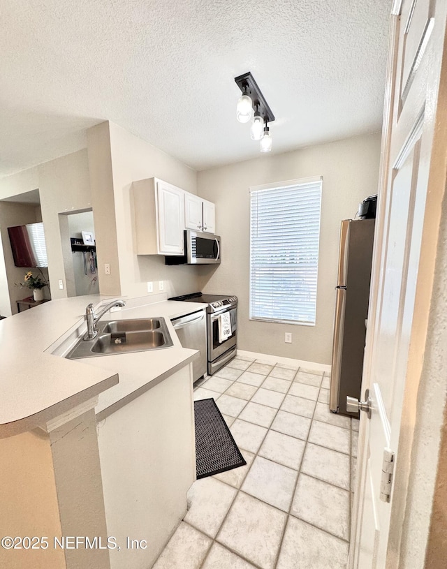 13703 Richmond Park Dr N Unit 2902, Jacksonville, FL 32224 - kitchen featuring stainless steel appliances, a peninsula, a sink, white cabinetry, and light countertops