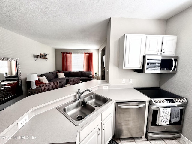 13703 Richmond Park Dr N Unit 2902, Jacksonville, FL 32224 - kitchen featuring stainless steel appliances, a sink, open floor plan, light countertops, and white cabinetry