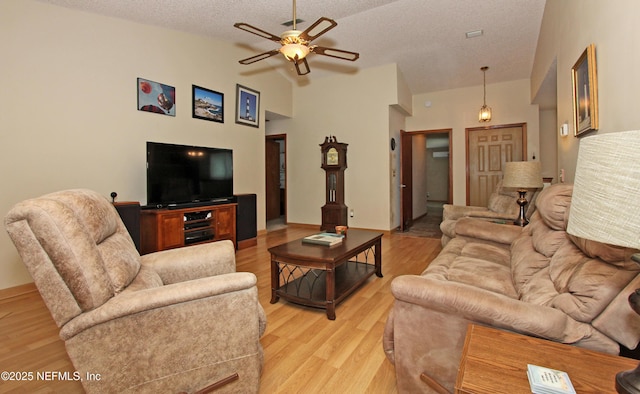 426 Harvest Bend Dr, Fleming Island, FL 32003 - living area with lofted ceiling, ceiling fan, a textured ceiling, and light wood-type flooring