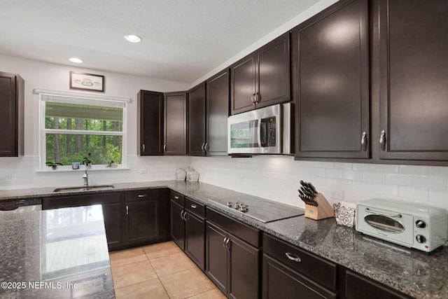1090 Wetland Ridge Cir, Middleburg, FL 32068 - kitchen featuring a sink, stainless steel microwave, black electric stovetop, dark stone counters, and tasteful backsplash
