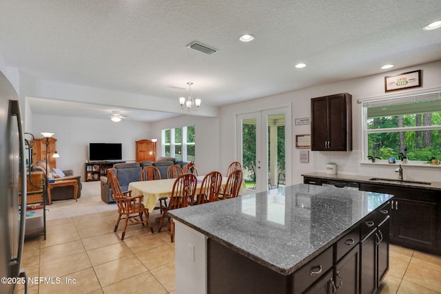 1090 Wetland Ridge Cir, Middleburg, FL 32068 - kitchen featuring a sink, light tile patterned floors, a kitchen island, recessed lighting, and dark brown cabinets
