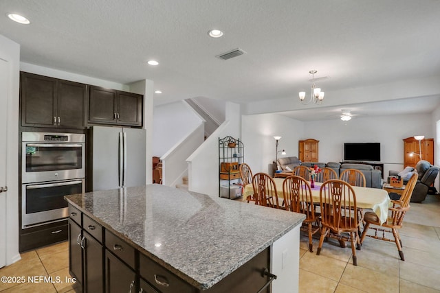 1090 Wetland Ridge Cir, Middleburg, FL 32068 - kitchen with double oven, freestanding refrigerator, light tile patterned floors, open floor plan, and ceiling fan
