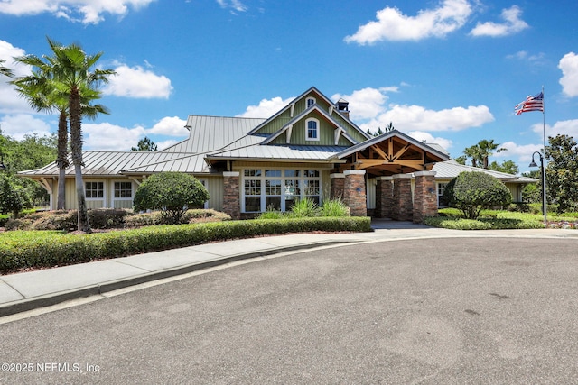 1090 Wetland Ridge Cir, Middleburg, FL 32068 - view of front facade featuring a standing seam roof, stone siding, a chimney, metal roof, and board and batten siding