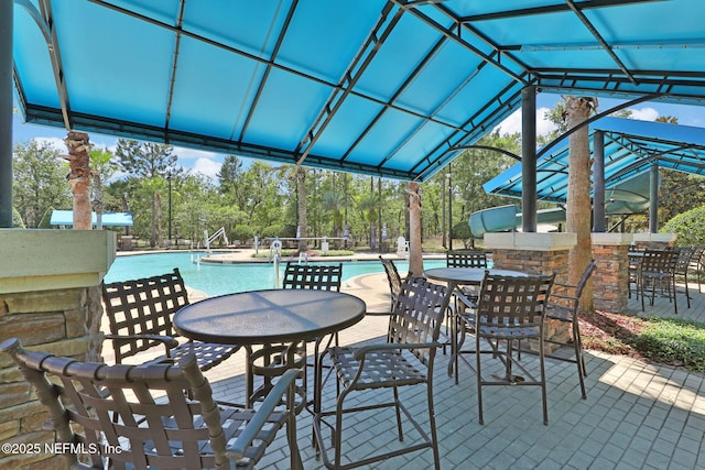 1090 Wetland Ridge Cir, Middleburg, FL 32068 - view of patio featuring a community pool, an outdoor bar, and view of wooded area