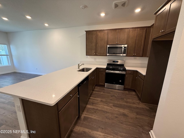 13525 Ute Pl, Jacksonville, FL 32218 - kitchen featuring appliances with stainless steel finishes, a sink, dark wood finished floors, a peninsula, and recessed lighting