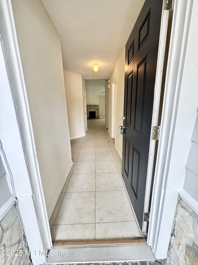 3951 Hunters Lake Cir W, Jacksonville, FL 32210 - hallway featuring a textured ceiling, baseboards, and light tile patterned floors
