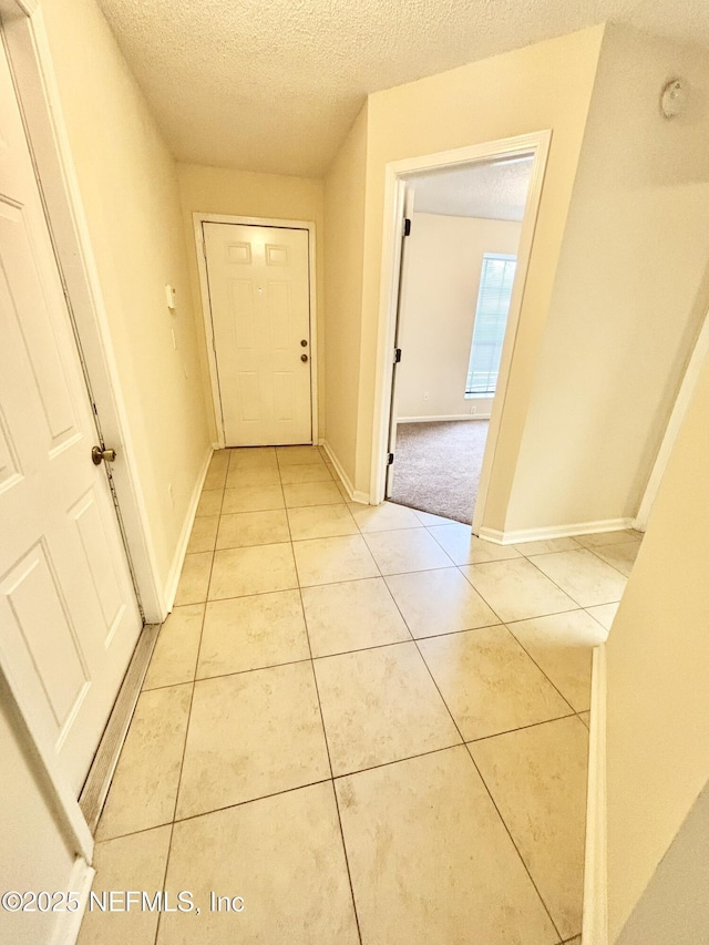 3951 Hunters Lake Cir W, Jacksonville, FL 32210 - hallway featuring a textured ceiling, light tile patterned floors, and baseboards