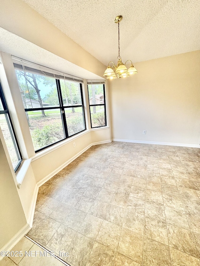 3951 Hunters Lake Cir W, Jacksonville, FL 32210 - spare room with a chandelier, healthy amount of natural light, a textured ceiling, and baseboards