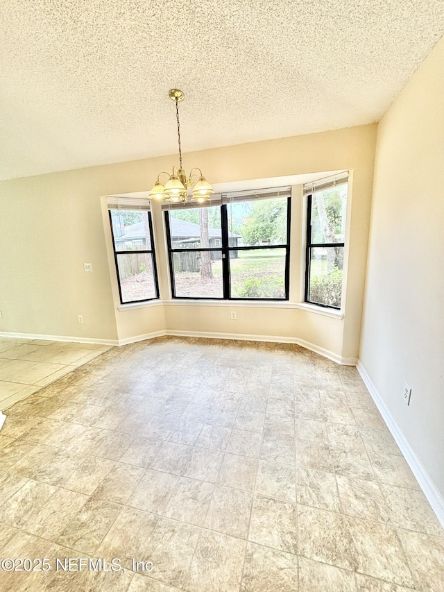 3951 Hunters Lake Cir W, Jacksonville, FL 32210 - tiled empty room with a chandelier, a textured ceiling, and baseboards