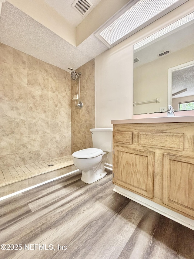 3951 Hunters Lake Cir W, Jacksonville, FL 32210 - full bathroom featuring wood finished floors, toilet, tiled shower, vanity, and a textured ceiling