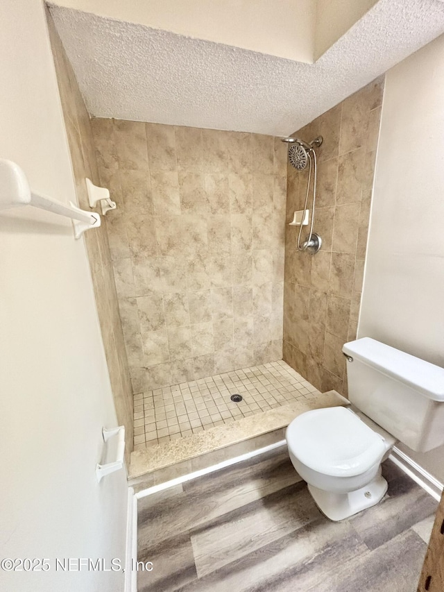 3951 Hunters Lake Cir W, Jacksonville, FL 32210 - bathroom with a shower stall, a textured ceiling, toilet, and wood finished floors