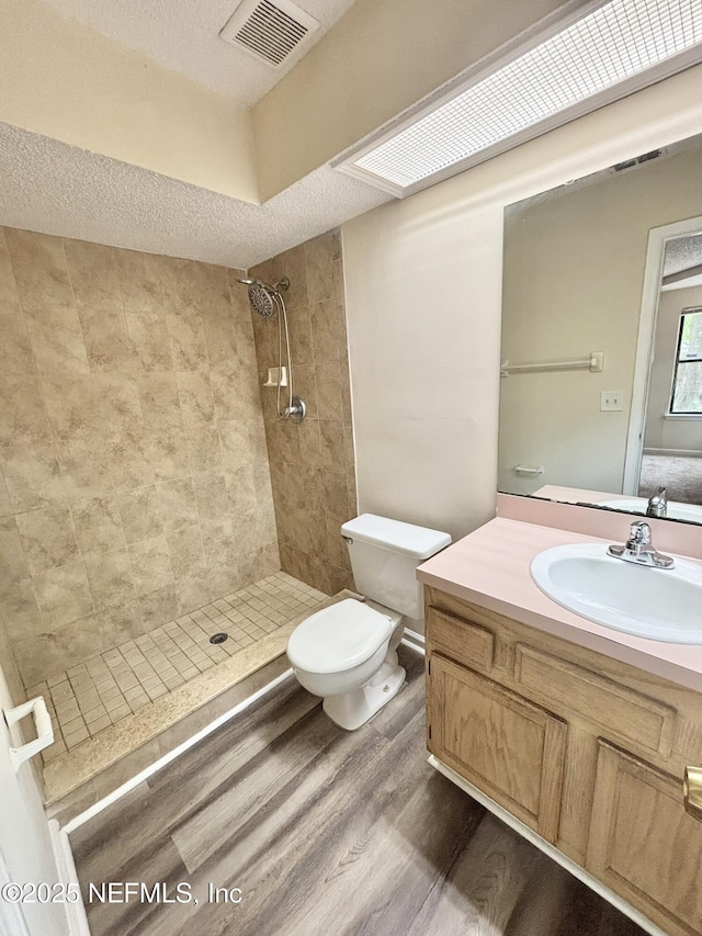 3951 Hunters Lake Cir W, Jacksonville, FL 32210 - full bath featuring wood finished floors, toilet, tiled shower, vanity, and a textured ceiling