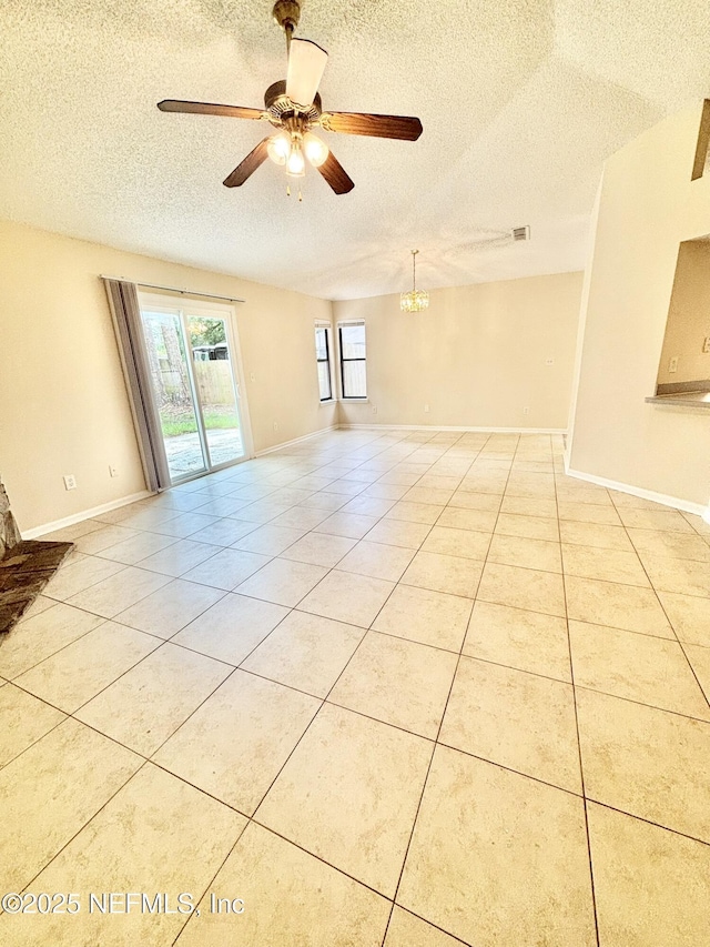 3951 Hunters Lake Cir W, Jacksonville, FL 32210 - empty room featuring a textured ceiling, light tile patterned flooring, a ceiling fan, a chandelier, and baseboards