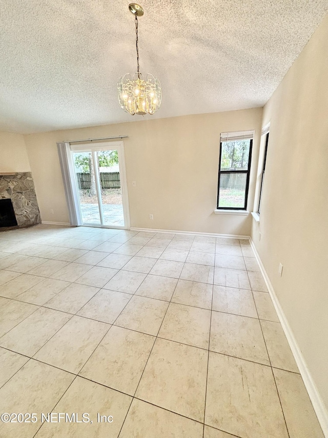 3951 Hunters Lake Cir W, Jacksonville, FL 32210 - tiled spare room with a textured ceiling, a chandelier, a stone fireplace, and baseboards