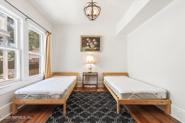 27 Grant St, Saint Augustine, FL 32084 - bedroom with a chandelier, wood finished floors, and baseboards