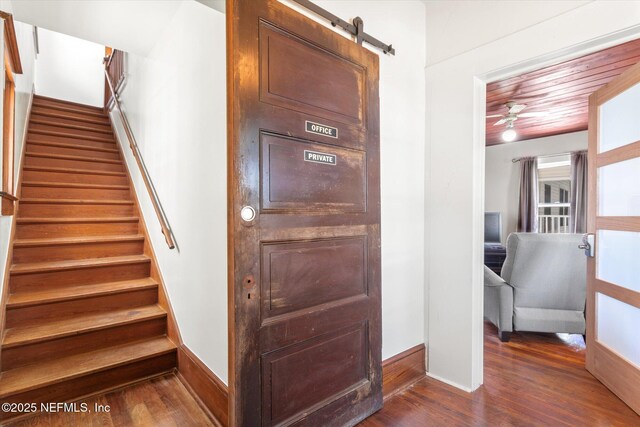 27 Grant St, Saint Augustine, FL 32084 - stairway featuring wood finished floors, baseboards, ceiling fan, and a barn door