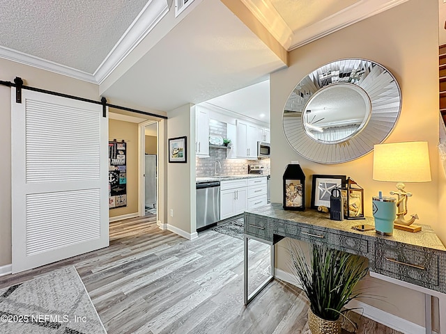 5375 Ortega Farms Blvd Unit 1011, Jacksonville, FL 32210 - hall with a barn door, light wood finished floors, crown molding, baseboards, and a textured ceiling