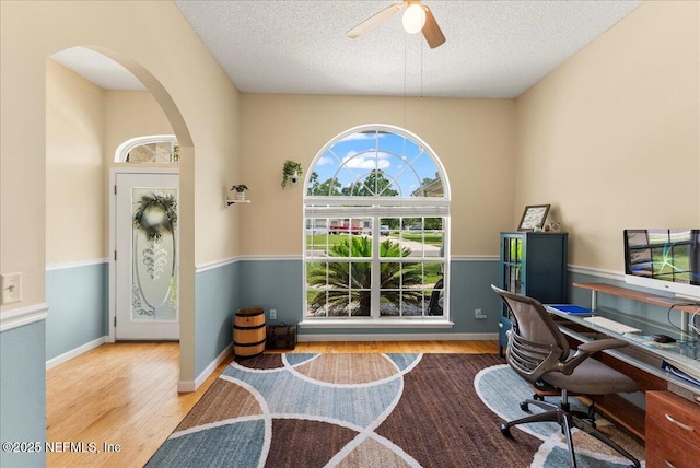 3910 Selig Ct, Middleburg, FL 32068 - office space featuring wood finished floors, arched walkways, a ceiling fan, a textured ceiling, and baseboards