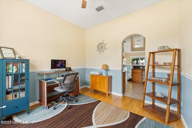 3910 Selig Ct, Middleburg, FL 32068 - office with arched walkways, light wood-style floors, ceiling fan, vaulted ceiling, and baseboards