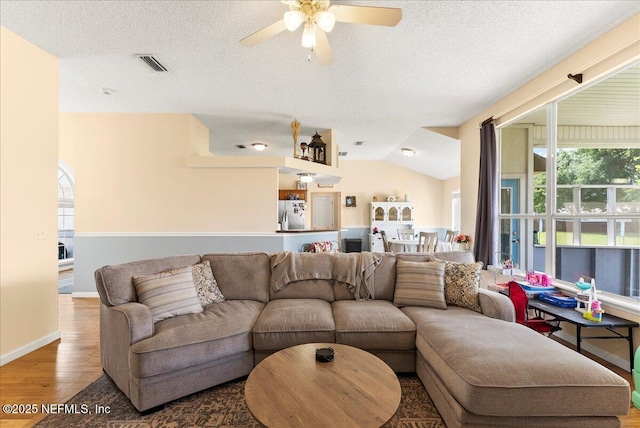 3910 Selig Ct, Middleburg, FL 32068 - living room featuring wood finished floors, ceiling fan, a textured ceiling, baseboards, and vaulted ceiling