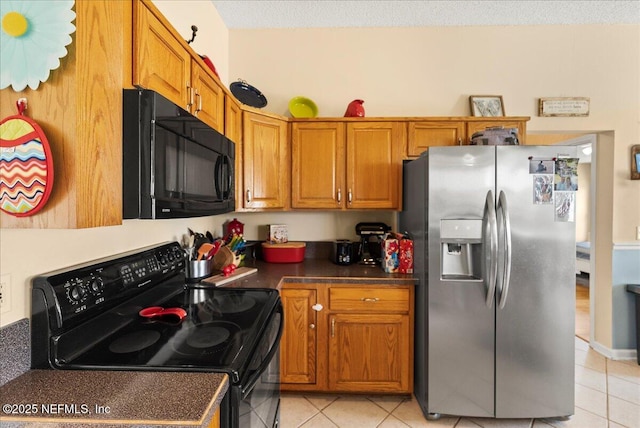3910 Selig Ct, Middleburg, FL 32068 - kitchen with black appliances, light tile patterned floors, brown cabinets, dark countertops, and a textured ceiling