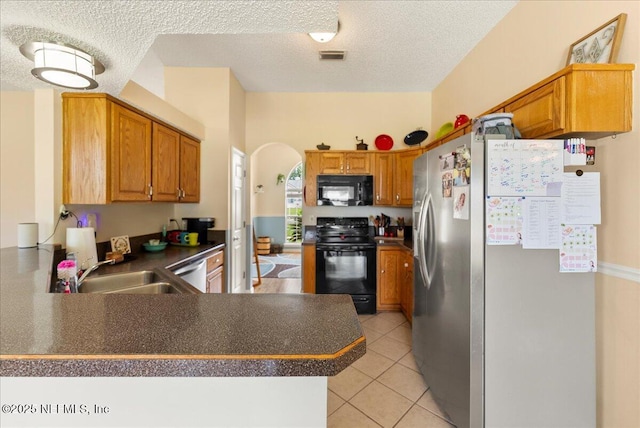 3910 Selig Ct, Middleburg, FL 32068 - kitchen with black appliances, a sink, arched walkways, a textured ceiling, and a peninsula