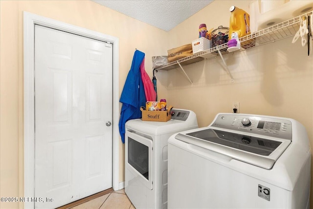 3910 Selig Ct, Middleburg, FL 32068 - laundry area with washing machine and clothes dryer, light tile patterned flooring, and a textured ceiling