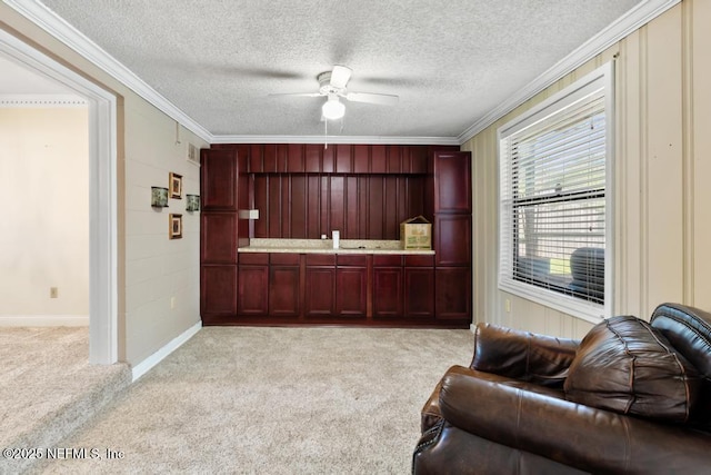1133 Gunka Rd, Jacksonville, FL 32216 - kitchen with reddish brown cabinets, open floor plan, a ceiling fan, light carpet, and ornamental molding