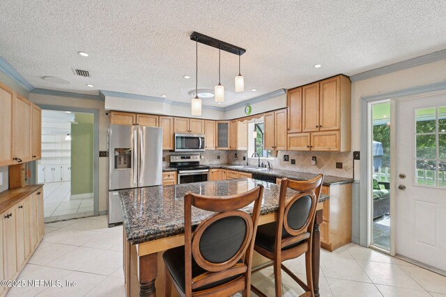9620 Baylor Ave, Hastings, FL 32145 - kitchen with stainless steel appliances, a sink, light tile patterned flooring, backsplash, and a kitchen breakfast bar