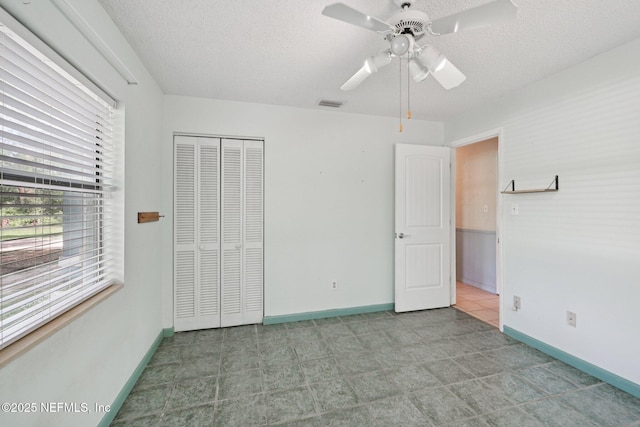 9620 Baylor Ave, Hastings, FL 32145 - unfurnished bedroom with baseboards, a textured ceiling, a closet, and ceiling fan
