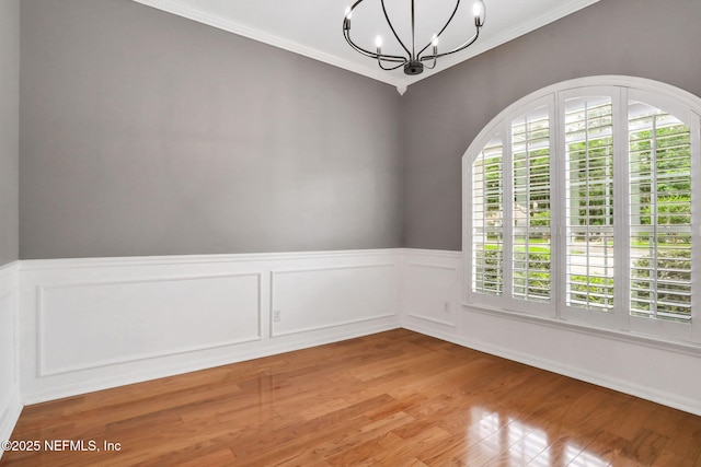 880 Buckeye Ln W, Saint Johns, FL 32259 - spare room with a chandelier, ornamental molding, light wood-style flooring, and a wainscoted wall