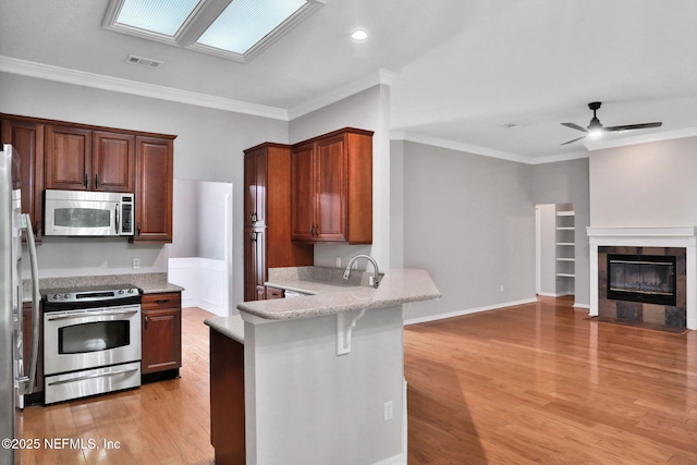 880 Buckeye Ln W, Saint Johns, FL 32259 - kitchen with appliances with stainless steel finishes, open floor plan, a peninsula, light wood finished floors, and a ceiling fan