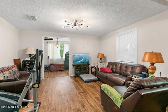 3020 Gilmore St, Jacksonville, FL 32205 - living room with wood finished floors, a textured ceiling, and a chandelier