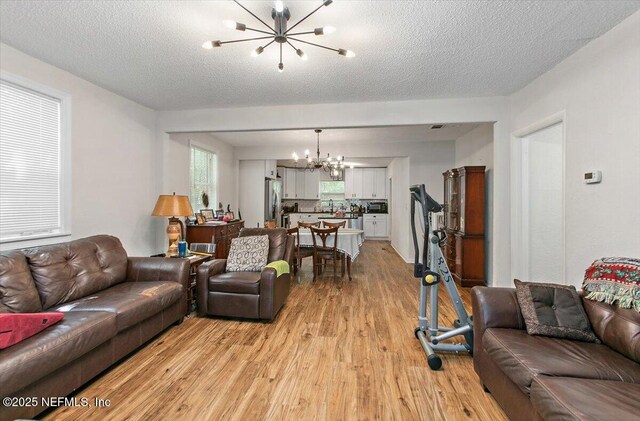 3020 Gilmore St, Jacksonville, FL 32205 - living area with a chandelier, light wood finished floors, and a textured ceiling