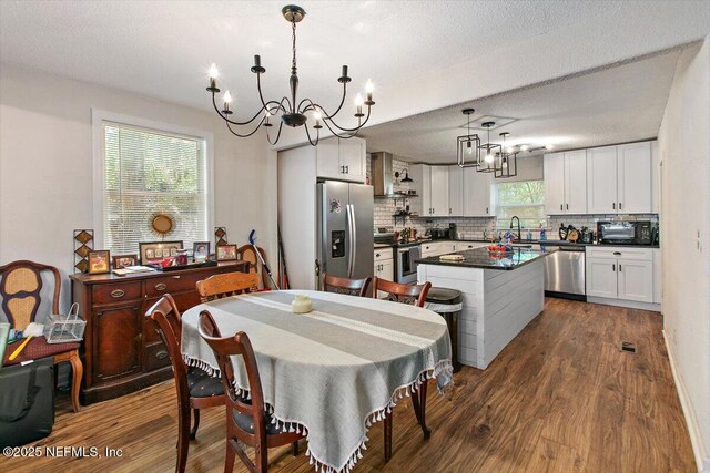 3020 Gilmore St, Jacksonville, FL 32205 - dining room featuring a chandelier, dark wood finished floors, and a textured ceiling