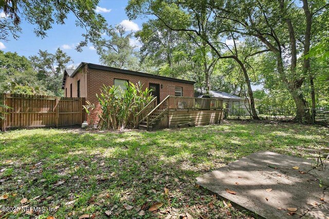 3020 Gilmore St, Jacksonville, FL 32205 - back of property featuring brick siding, a fenced backyard, and a deck