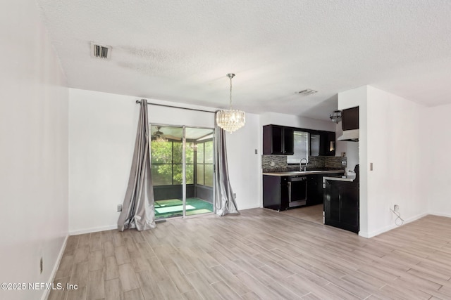 1247 Turtle Creek Dr N, Jacksonville, FL 32218 - kitchen with dishwashing machine, a textured ceiling, tasteful backsplash, baseboards, and a chandelier