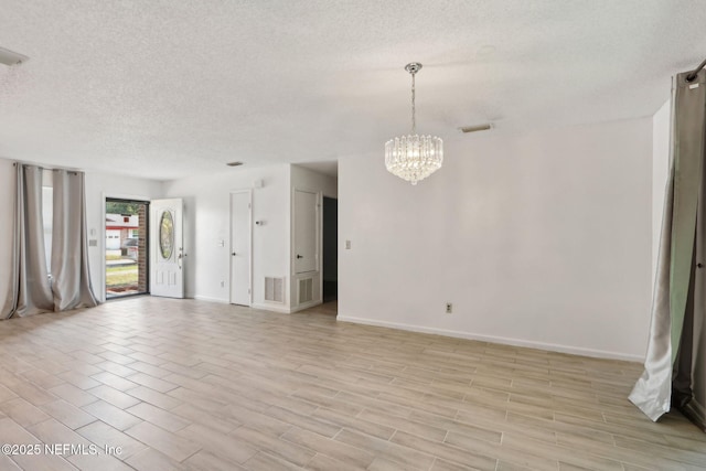 1247 Turtle Creek Dr N, Jacksonville, FL 32218 - empty room featuring a textured ceiling, a chandelier, and baseboards