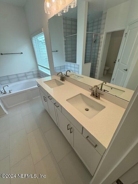 193 Silver Heron Way, Saint Augustine, FL 32092 - bathroom featuring a bath, double vanity, tile patterned flooring, a stall shower, and toilet