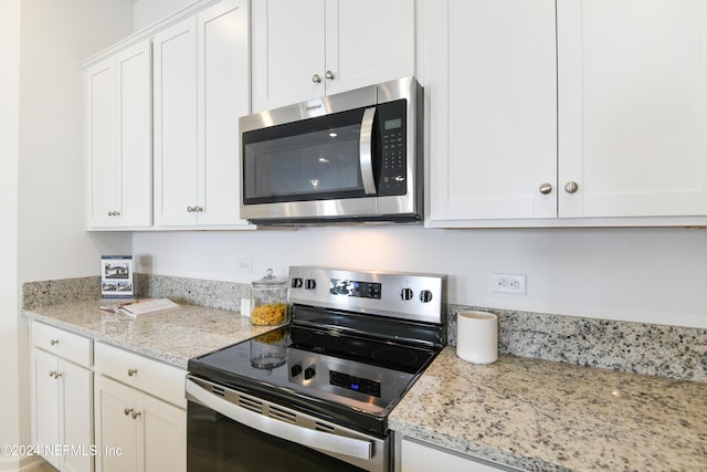 3369 Golden Eye Dr, Orange Park, FL 32065 - kitchen with stainless steel appliances, white cabinetry, and light stone counters